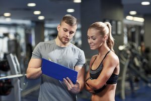 treinador dando dicas de musculação para aluna